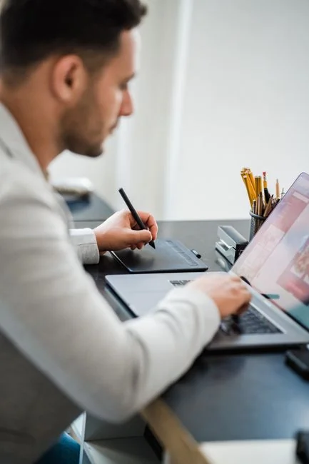 Un bureau de travail élégant et épuré mettant en scène des appareils Apple : iMac, MacBook et iPad.